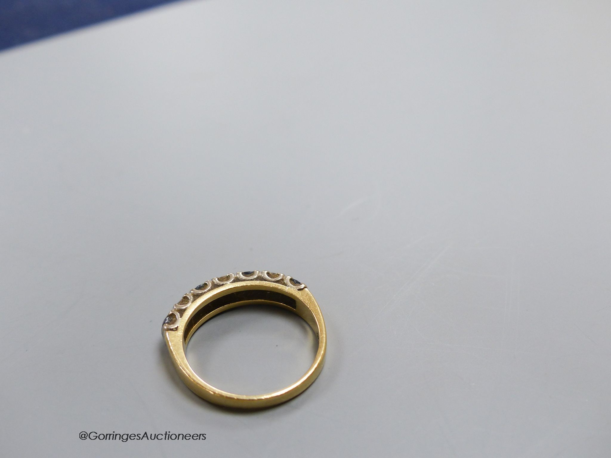 An 18ct gold sapphire and diamond seven stone ring, size N, gross 4g.